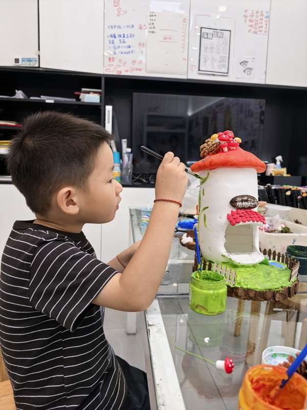 孩子专注为立体美术作品添加颜色与细节
